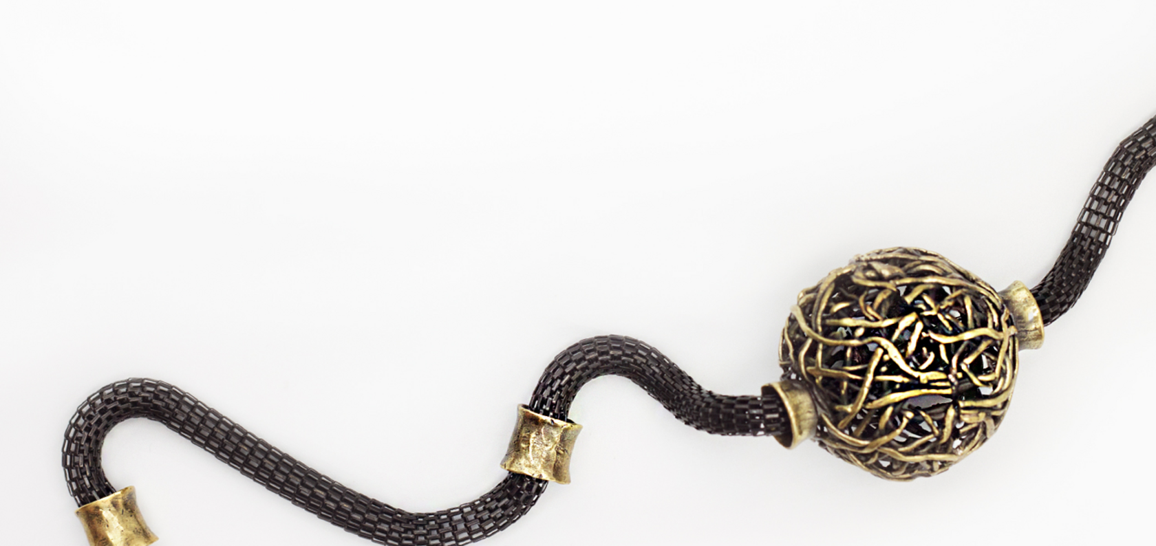 Woven bronze sphere on a dark mesh chain